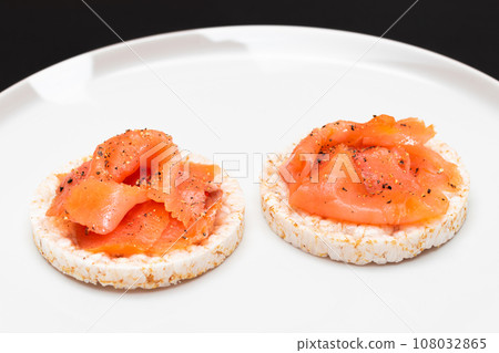 Rice Cake Sandwiches with Fresh Salmon Slices on White Plate 108032865