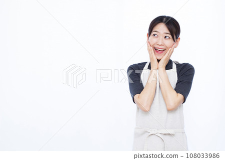 A housewife in her 30s smiling and surprised in front of a white background 108033986