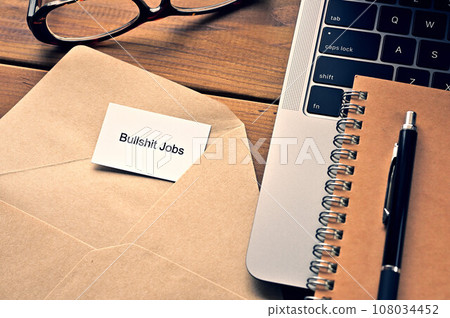 Desk with a card that says Bullshit Jobs 108034452
