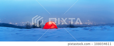 Winter panorama with red tent lighted from the inside 108034611