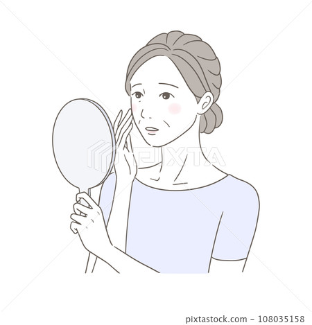 A senior woman is confused by the changes in her skin looking in a hand mirror. 108035158