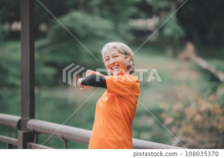 white-haired elderly person exercising in the park early in the morning. white-haired elderly person exercising in the park early in the morning. 108035370
