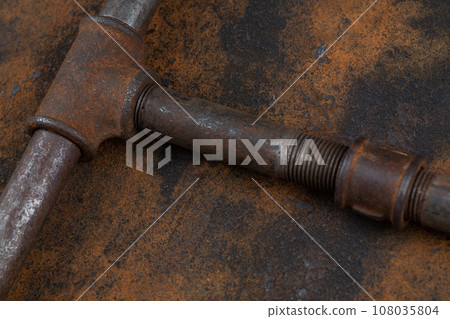 Rusty plumb tube on rusty metal wall Rusty plumb tube on rusty metal wall 108035804