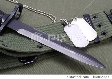 M16 rifle bayonet on uniform background 108035843