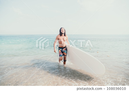 Sea man sup. Asian athlete man swimming in sea and paddleboarding at summer sunset. Healthy strong male enjoy outdoor active lifestyle and water sports on holiday vacation. 108036010