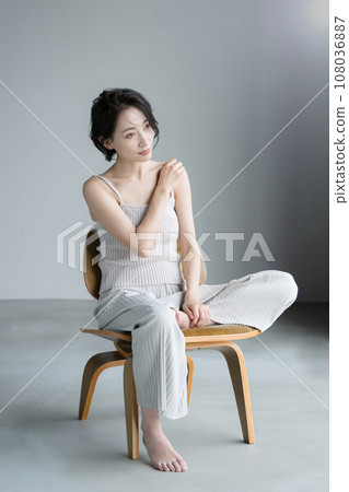 Beautiful woman sitting on a chair Beautiful woman sitting on a chair 108036887