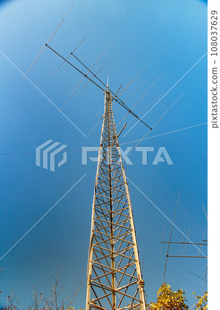 A steel tower that shines against the blue autumn sky A steel tower that shines against the blue autumn sky 108037629