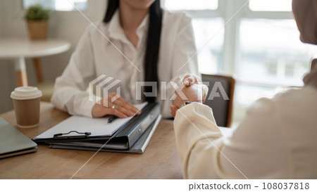 A beautiful Asian businesswoman is shaking her hand with a client after the meeting. 108037818