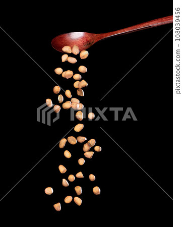 Peanut fall, brown grain peanuts explode abstract cloud fly from wooden spoon. Beautiful complete seed pea peanuts, food object design. Selective focus freeze shot black background isolated Peanut fall, brown grain peanuts explode abstract cloud fly from wooden spoon. Beautiful complete seed pea peanuts, food object design. Selective focus freeze shot black background isolated 108039456