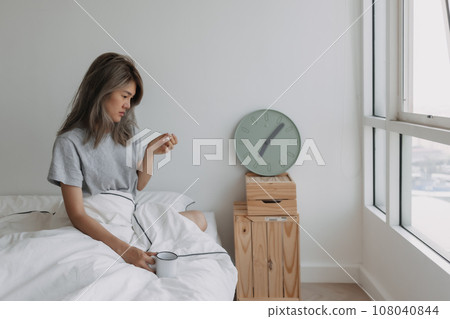 Woman just wake up by the at clock 7 AM on the bed in the morning. Woman just wake up by the at clock 7 AM on the bed in the morning. 108040844