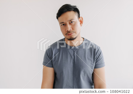 Bored and tried face of asian man in blue t-shirt stand isolated on white Bored and tried face of asian man in blue t-shirt stand isolated on white 108041022
