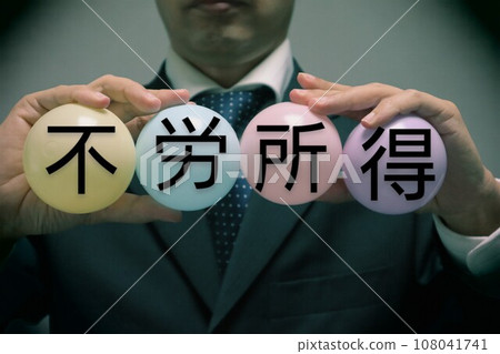 A person holding a ball that says passive income 108041741