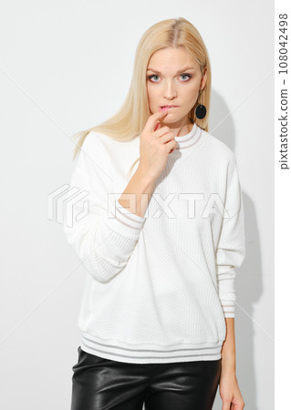 Distrustful or doubting woman biting her lip Distrustful or doubting woman biting her lip 108042498