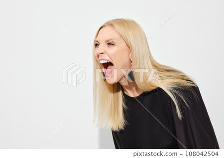 Woman screams in irritation leaning forward 108042504