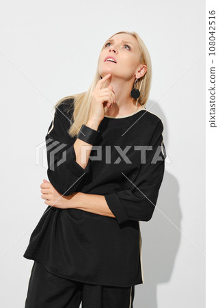 Curious blonde woman looking up Curious blonde woman looking up 108042516