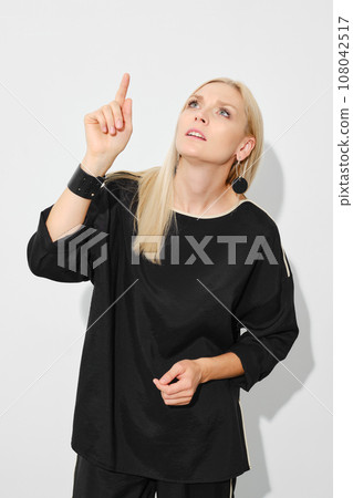 Pretty woman pointing finger up 108042517
