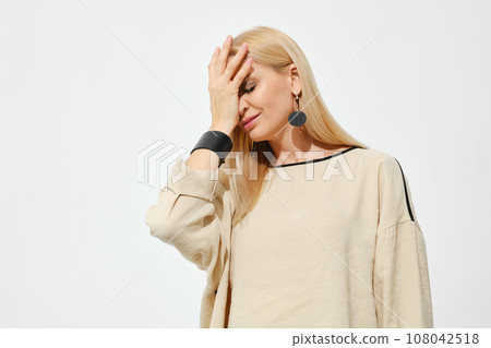 Woman makes facepalm gesture 108042518