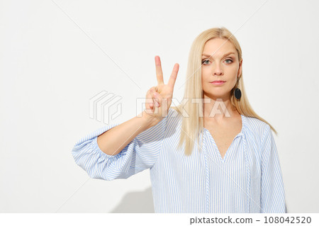 Woman shows two fingers. Counting with fingers. 108042520