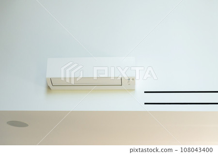 The air conditioner is hanging on the wall in the room The air conditioner is hanging on the wall in the room 108043400