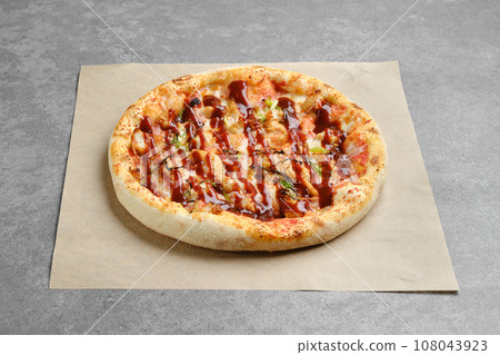 Barbecue pizza with bacon and spring onion on parchment Barbecue pizza with bacon and spring onion on parchment 108043923