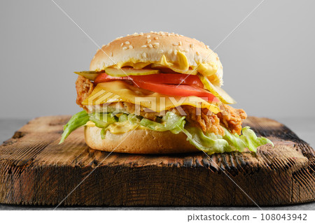 Chicken cheeseburger with fresh and pickled vegetables, front view 108043942
