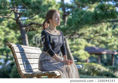 一個女人坐在長椅上眺望遠方 一個女人坐在長椅上眺望遠方 108044143