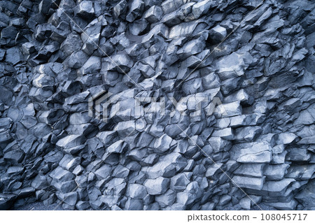 Basalt stones as a background. Image for background and wallpaper. Sharp rocks. 108045717