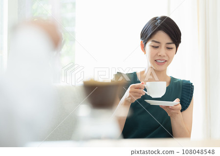 woman drinking coffee in the living room 108048548