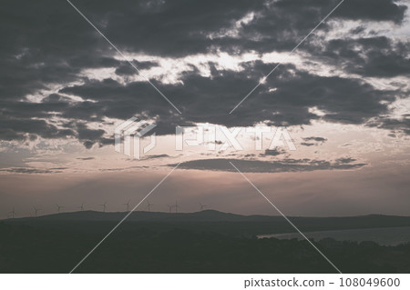 Abstract background sky Dawn Sunset Contrast dark shadow bright cloud sun orange silhouette above the mountains near the sea Abstract background sky Dawn Sunset Contrast dark shadow bright cloud sun orange silhouette above the mountains near the sea 108049600