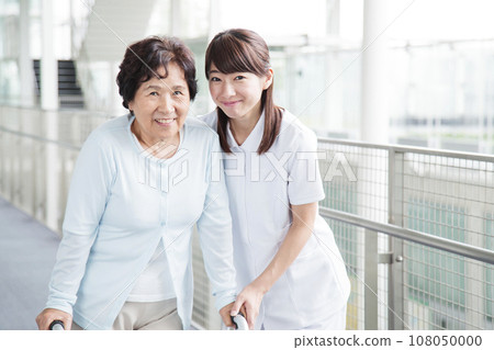 Young female caregiver caring for a senior woman 108050000