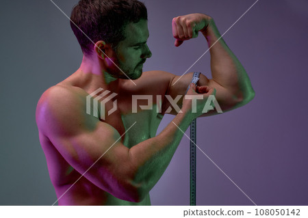 young man is interested interest in the size of their biceps 108050142