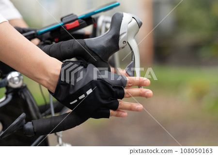 Young woman's hand holding the STI lever of a road bike Young woman's hand holding the STI lever of a road bike 108050163