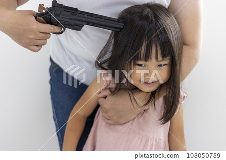 一名微笑的女孩(3歲,日本人)被玩具槍擊中頭部 一名微笑的女孩(3歲,日本人)被玩具槍擊中頭部 108050789