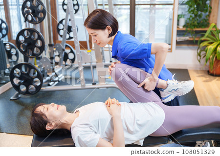在健身房接受個人伸展運動的女性 在健身房接受個人伸展運動的女性 108051329