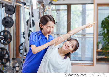 Woman receiving personal stretching at the gym 108051335