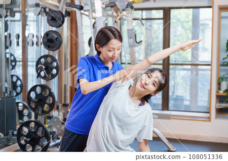 Woman receiving personal stretching at the gym 108051336