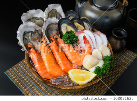 Seafood on a large plate set with dark background. Seafood on a large plate set with dark background. 108051623