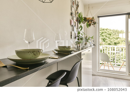 a dining table and chairs in a room with sliding glass doors that open onto the balcony overlooking out to the garden a dining table and chairs in a room with sliding glass doors that open onto the balcony overlooking out to the garden 108052043