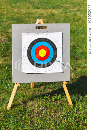 Archery target with arrow in bullseye 108052045