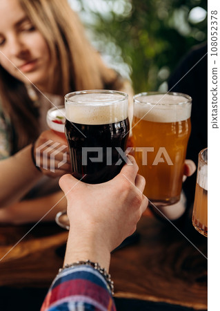 Friends toasting and drinking beer and cocktails in pub restaurant. Lifestyle party time concept Friends toasting and drinking beer and cocktails in pub restaurant. Lifestyle party time concept 108052378