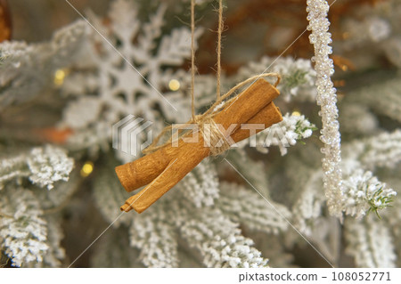 Christmas decoration on fir branches. Toy for Christmas-tree. Orange slice on the Xmas tree. Winter festive decor, flashing shiny lights. Many colorful balls, garland. Glittering illumination at night 108052771