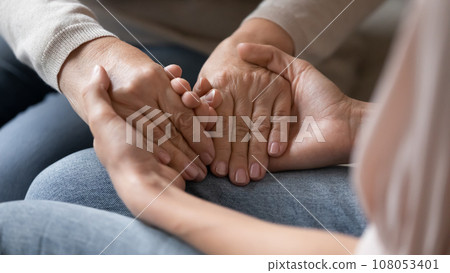 Closeup image adult daughter holding hands of old mother 108053401