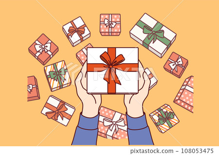 Gift box wrapped in red ribbon and bow in hands, demonstrating packaging options for holiday present 108053475