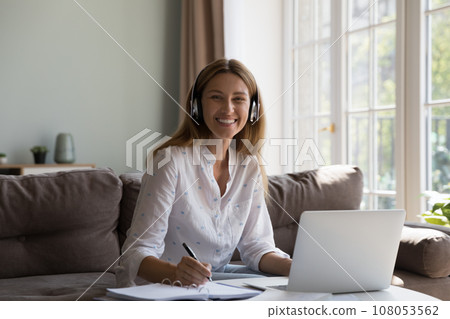 Happy cheerful freelance business woman in headphones working at laptop 108053562
