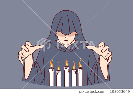 Man monk in hood stands over burning candles, performing mysterious religious ritual Man monk in hood stands over burning candles, performing mysterious religious ritual 108053649