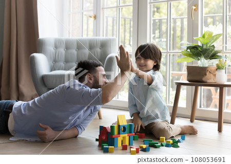 Happy father and little son boy playing constructing game Happy father and little son boy playing constructing game 108053691
