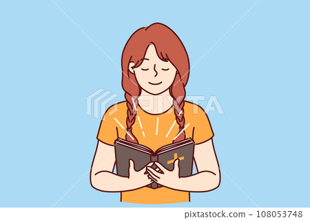 Little girl with bible in hands studies prayers and gospel before going to christian church 108053748