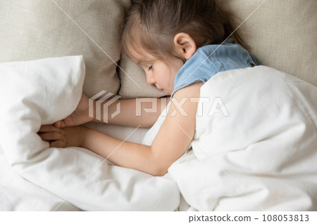 Top view of little girl sleeping in cozy home bed Top view of little girl sleeping in cozy home bed 108053813