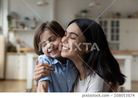 Head shot happy Asian mother and Caucasian son touching cheeks Head shot happy Asian mother and Caucasian son touching cheeks 108053874
