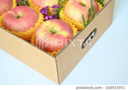 beautiful pink apple in the box on light blue background beautiful pink apple in the box on light blue background 108053951